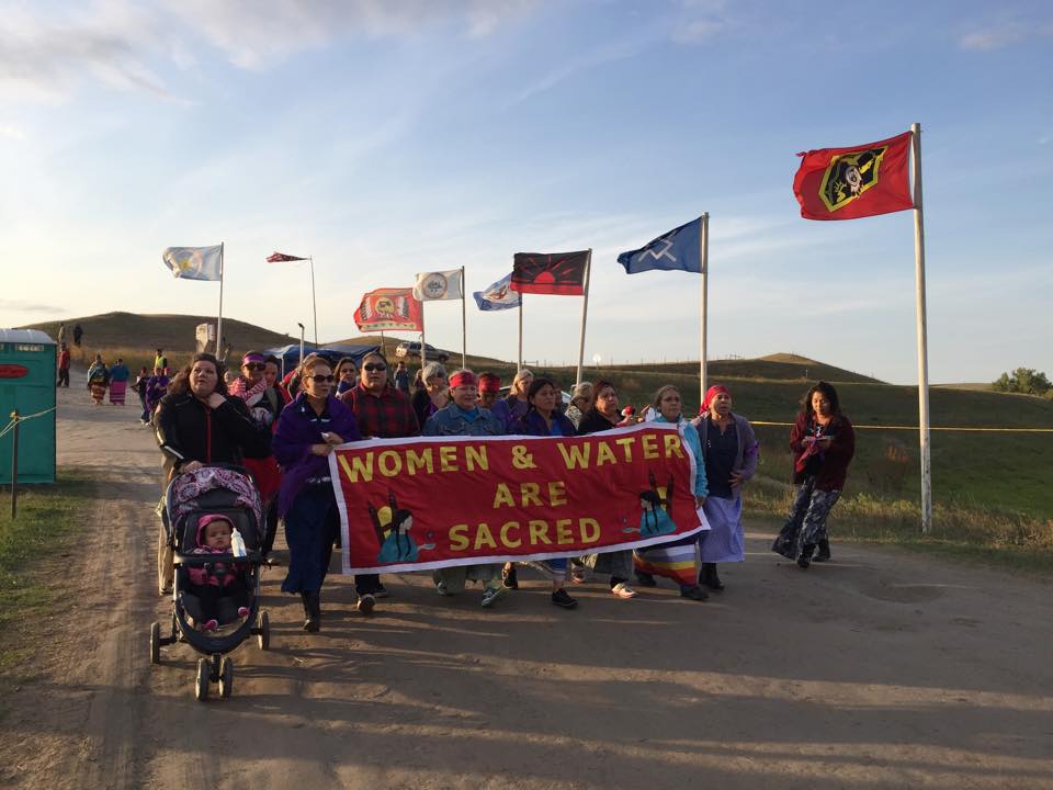 WOMEN AND WATER ARE SACRED; Tribal Coalitions walk into Sacred Stone Camp, Standing Rock Sioux Tribe, ND.